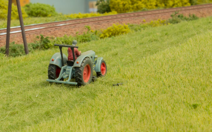 Høstmodul - detalje med landmanden der høster græs med traktor